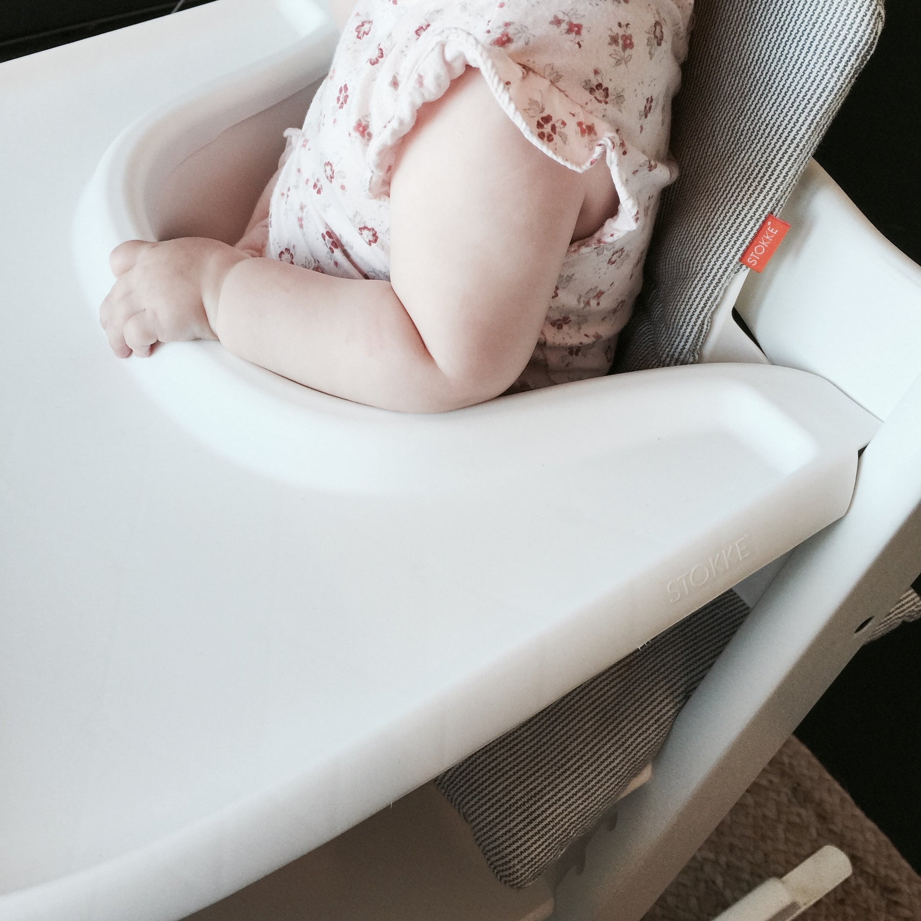 a baby sitting in her high chair waiting to discover what new delicious food her mom will be feeding her.